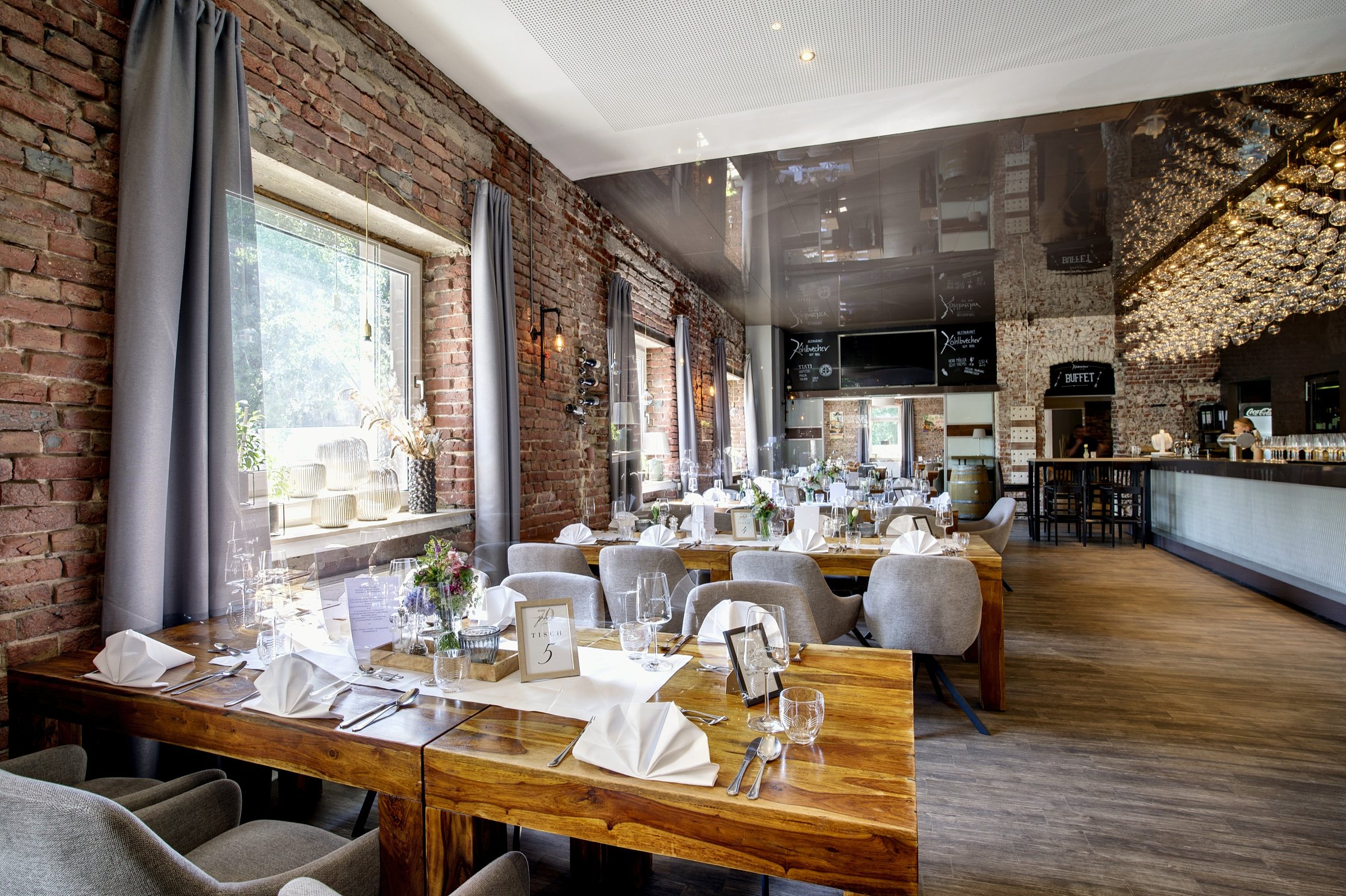 Restaurantsaal des Kohlbrecher mit Backsteinmauern und Blick zur Theke